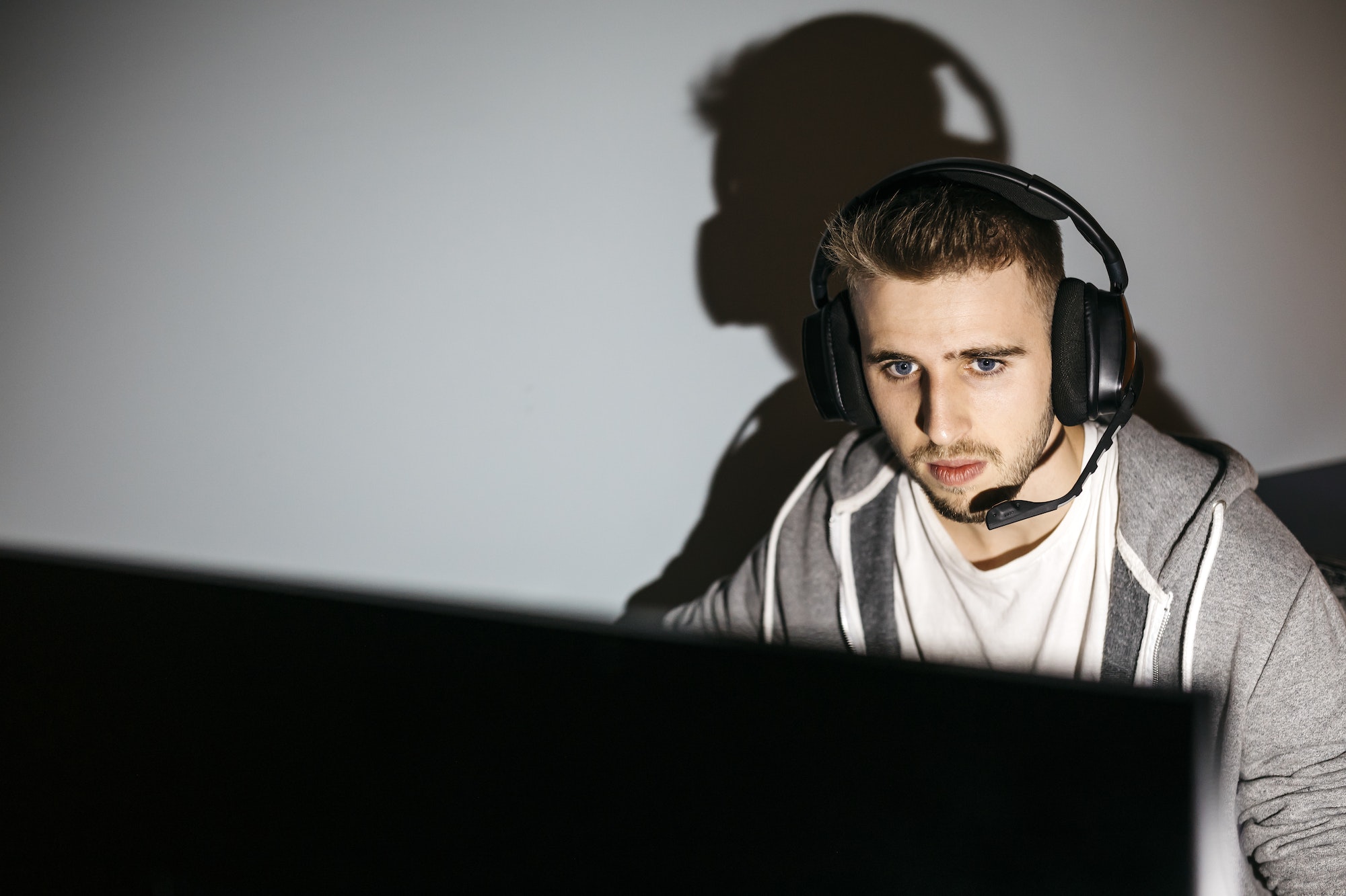 Young man sitting at his PC, playing computer games